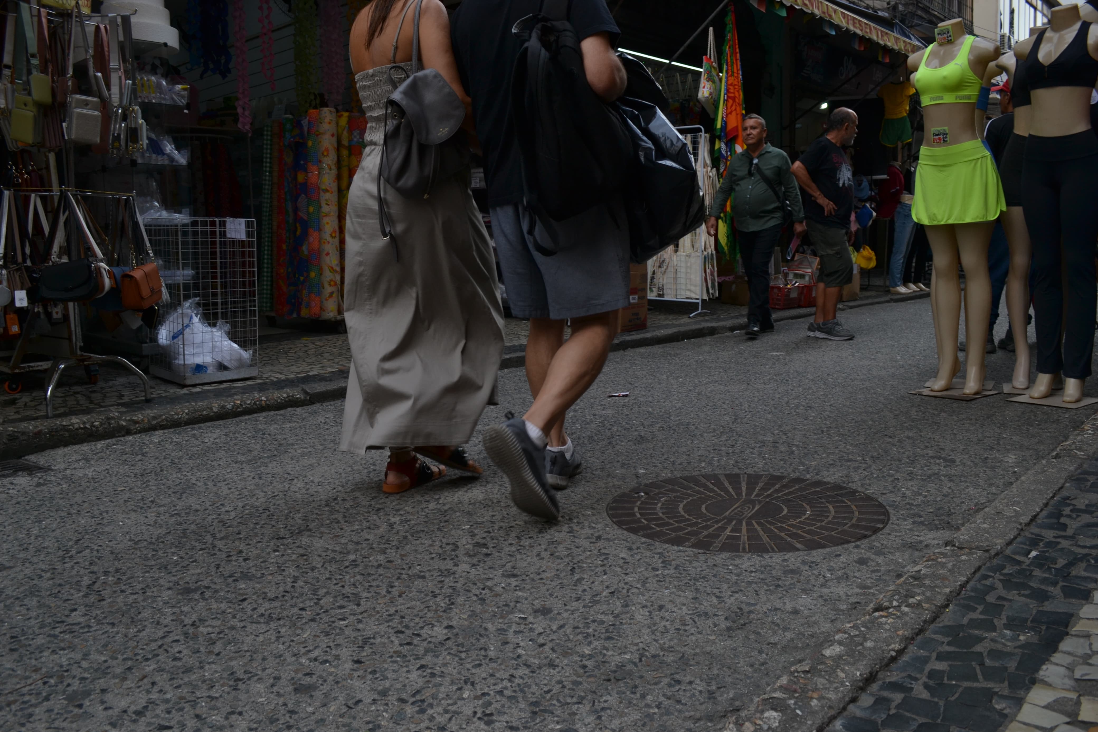Homem e mulher caminhando em uma rua não muito movimentada do Saara.